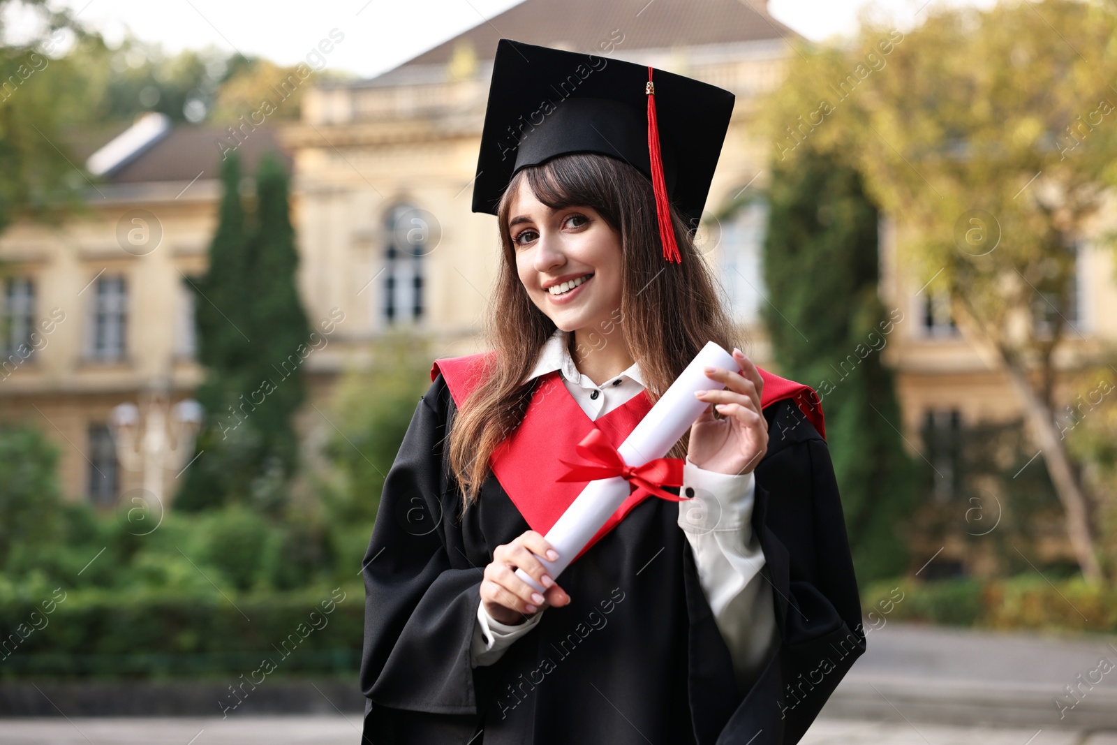 Photo of Happy student with diploma after graduation ceremony outdoors