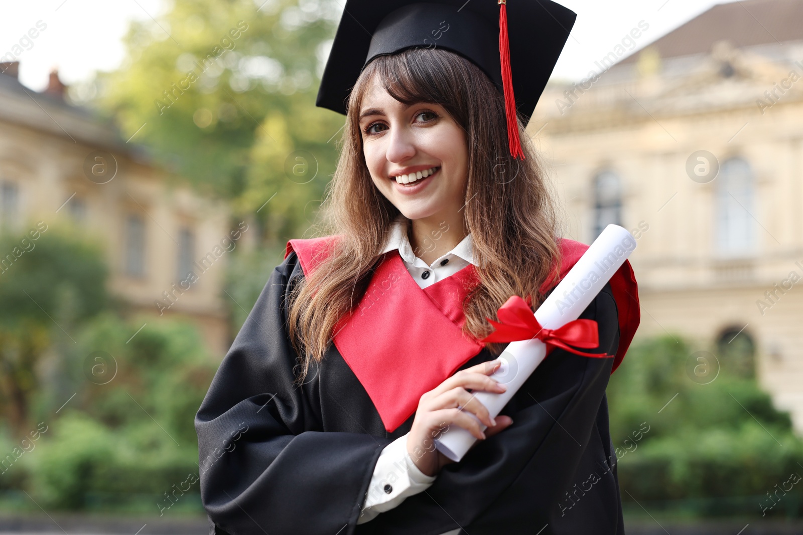 Photo of Happy student with diploma after graduation ceremony outdoors