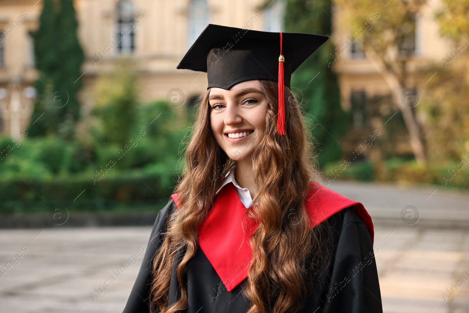 Photo of Graduation ceremony. Happy student in academic dress outdoors