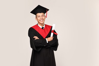 Photo of Happy student with diploma after graduation on light grey background. Space for text