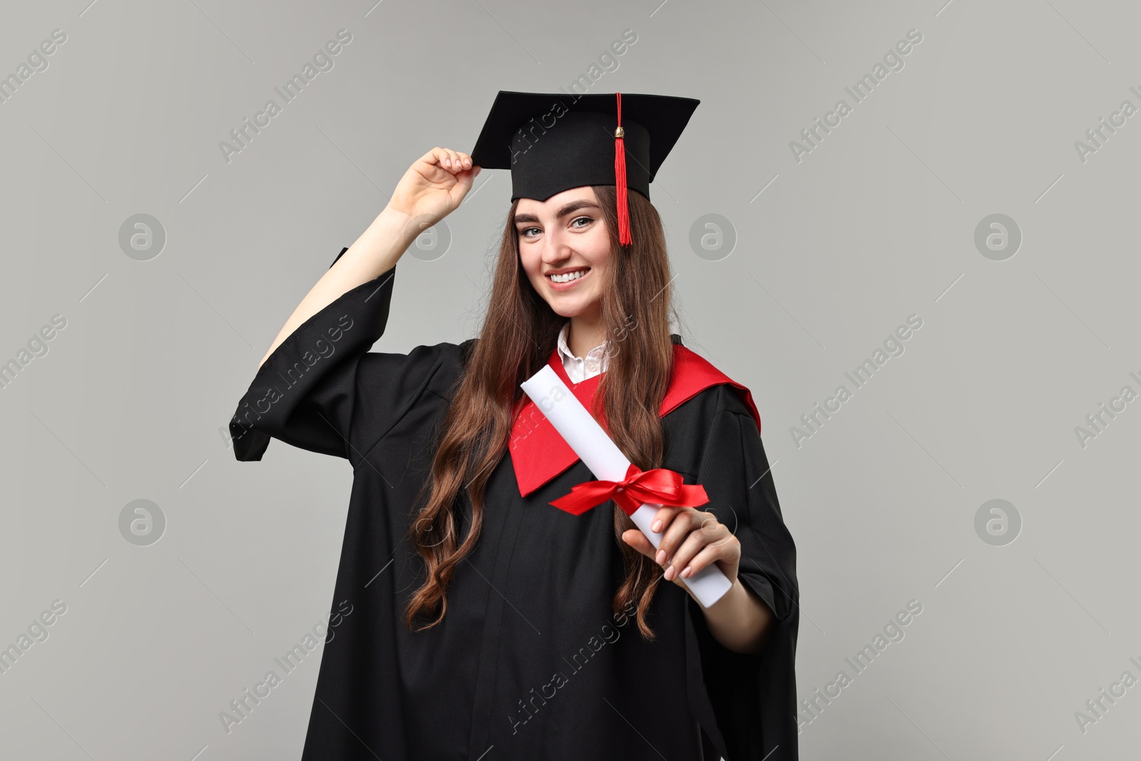 Photo of Happy student with diploma after graduation on grey background