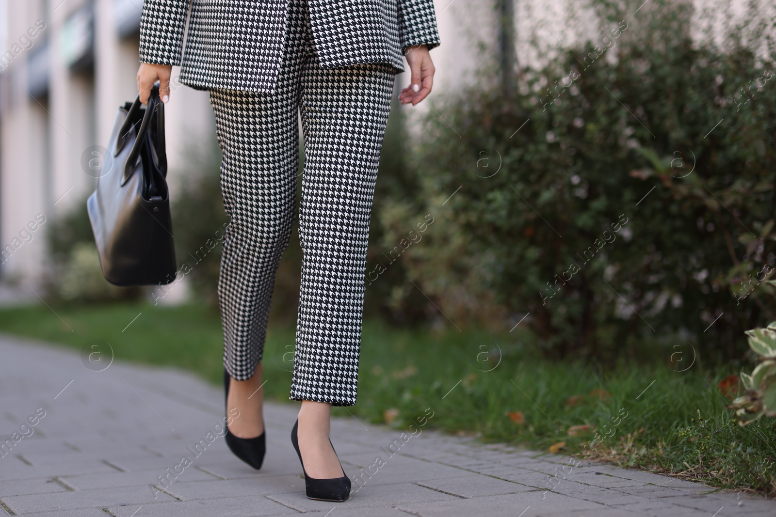 Photo of Businesswoman in stylish suit walking at work outdoors, closeup. Space for text