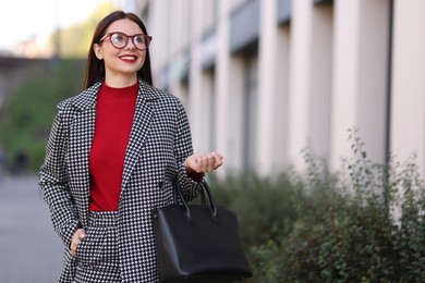 Photo of Beautiful woman in stylish suit outdoors. Space for text