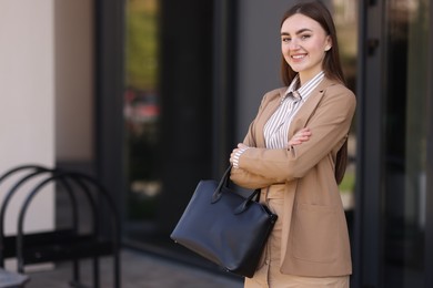 Beautiful woman in stylish suit outdoors. Space for text