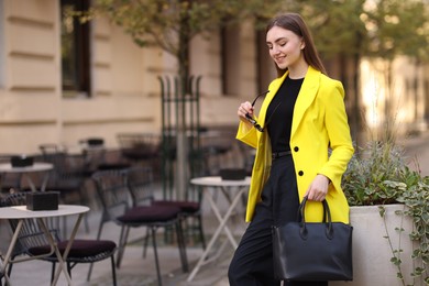 Beautiful woman in stylish suit outdoors. Space for text