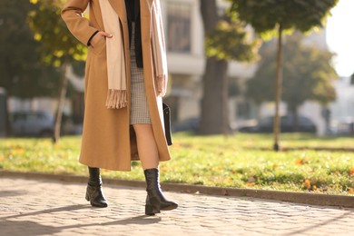 Photo of Businesswoman in stylish suit walking outdoors, closeup. Space for text