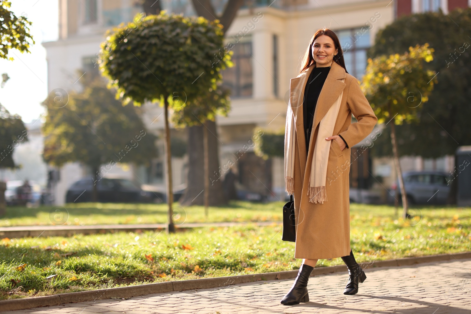 Photo of Smiling businesswoman in stylish suit walking outdoors. Space for text