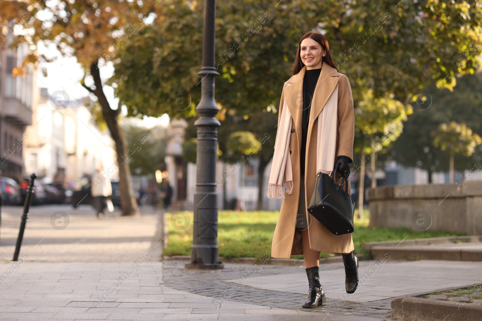 Photo of Smiling businesswoman in stylish suit walking outdoors. Space for text