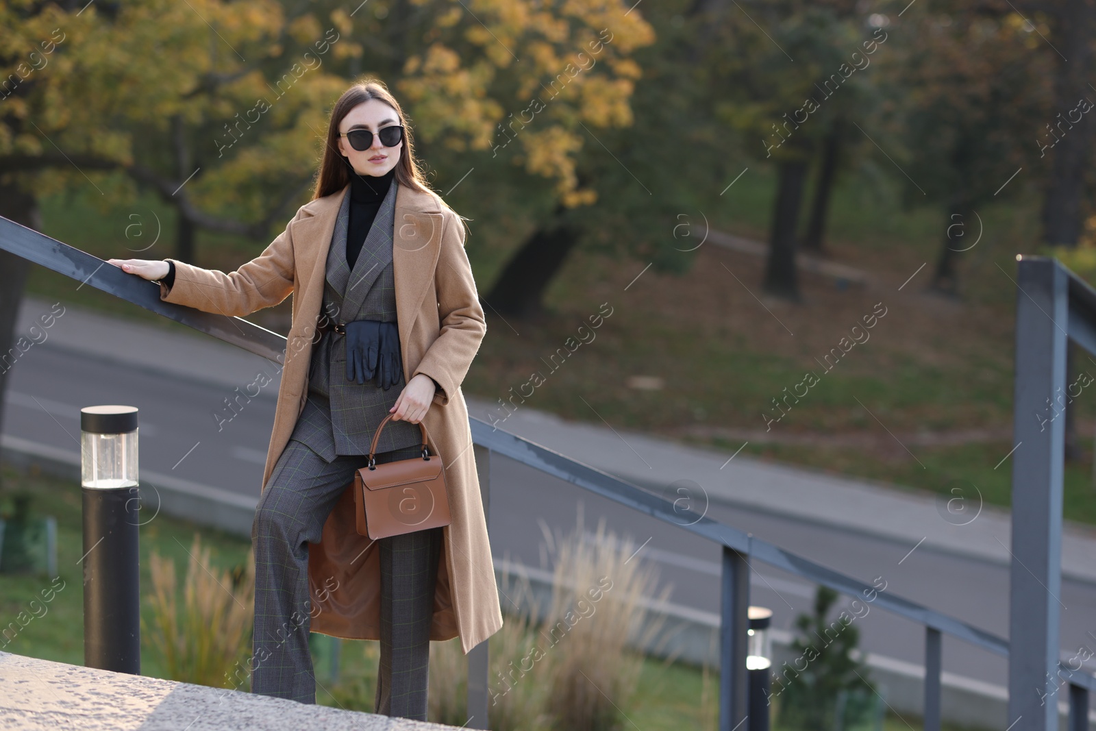 Photo of Beautiful woman in stylish suit outdoors. Space for text