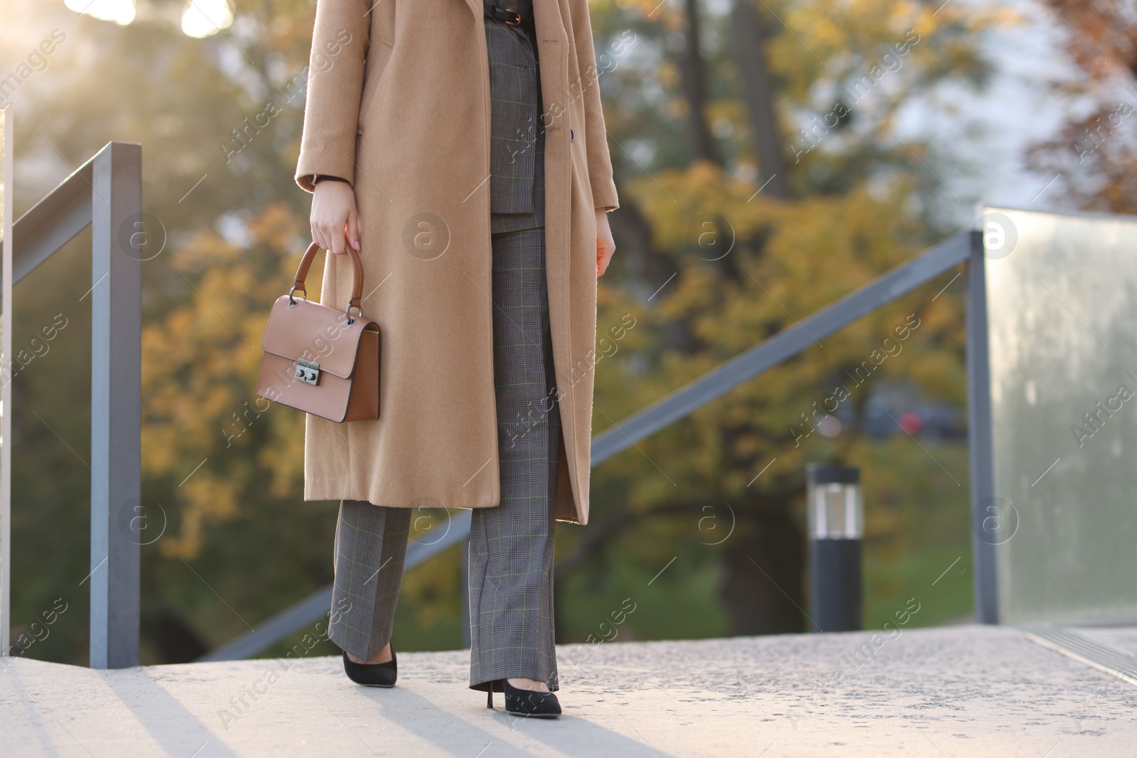 Photo of Businesswoman in stylish suit walking outdoors, closeup. Space for text