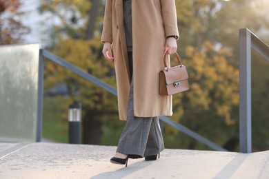 Photo of Businesswoman in stylish suit walking outdoors, closeup