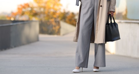 Photo of Businesswoman in stylish suit outdoors, closeup. Space for text