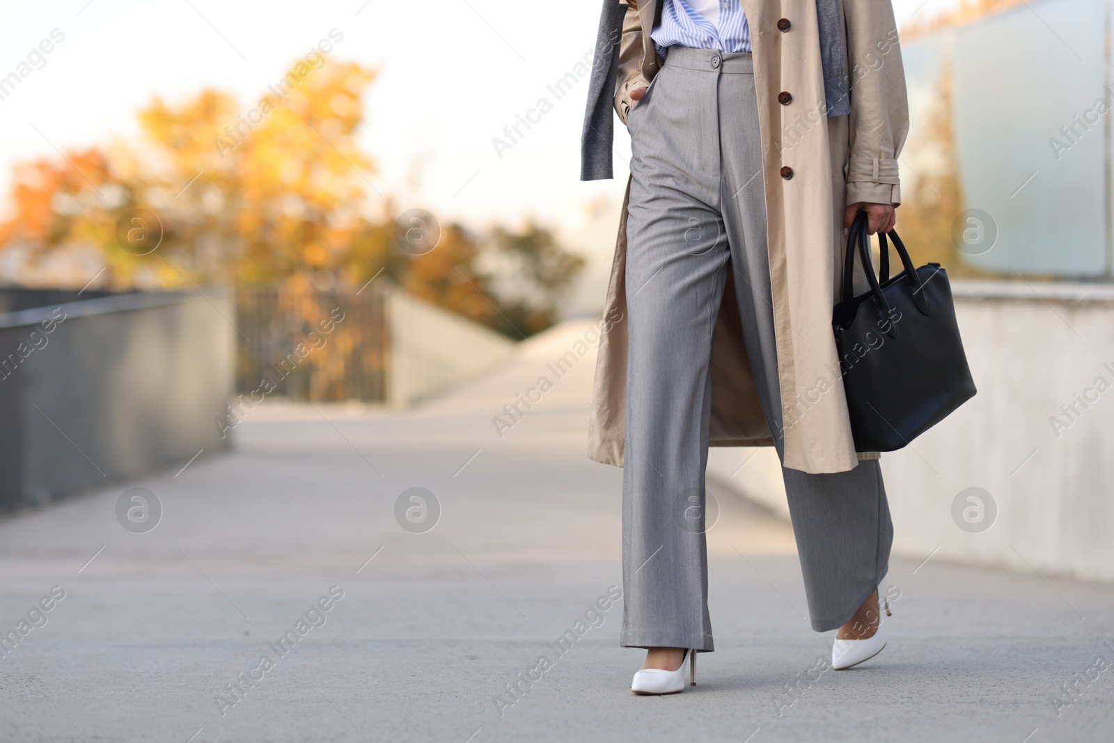 Photo of Businesswoman in stylish suit walking outdoors, closeup. Space for text