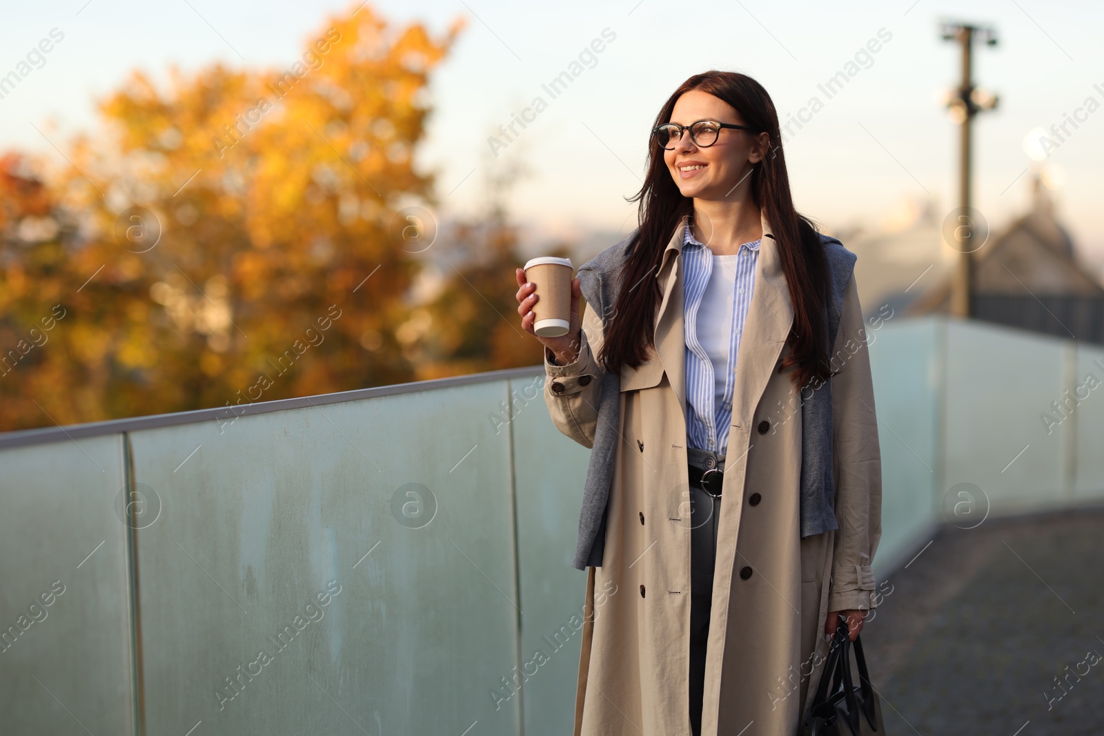 Photo of Beautiful woman in stylish suit with paper cup outdoors. Space for text