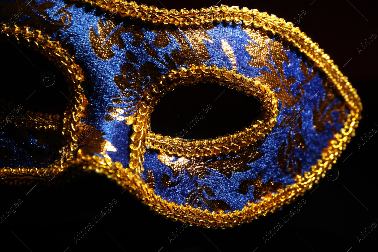 Photo of Beautiful blue carnival mask on black background, closeup