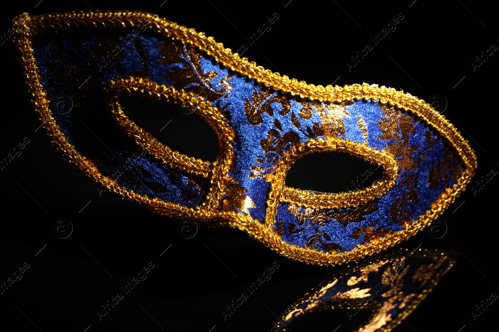 Photo of Beautiful blue carnival mask on black background, closeup