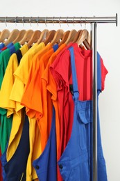 Photo of Workers' uniforms on clothing rack near grey wall indoors