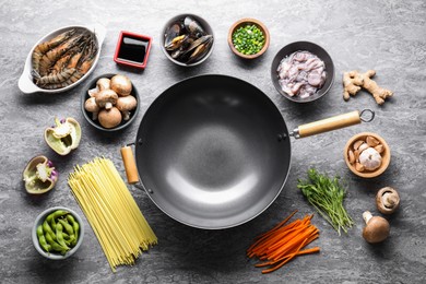 Photo of Different ingredients for wok on grey textured table, flat lay