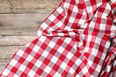 Crumpled tablecloth with checkered pattern on wooden table, top view