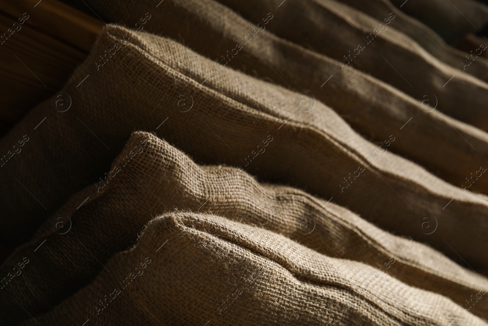 Photo of Closeup view of many natural burlap sacks