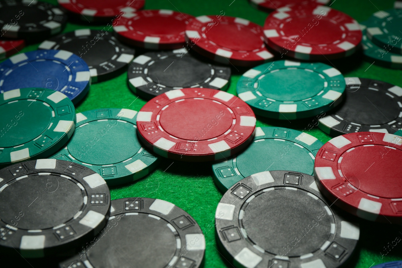 Photo of Group of poker chips on green table, closeup