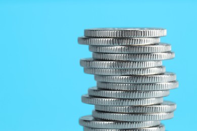 Photo of Salary concept. Stacked coins on light blue background, closeup. Space for text