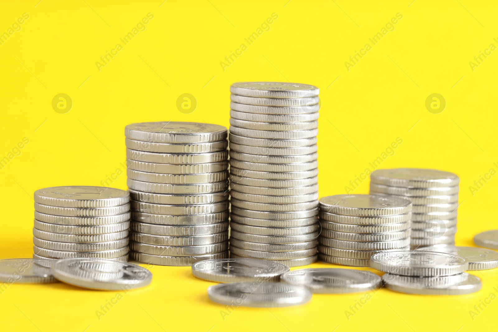 Photo of Salary concept. Stacked coins on yellow background