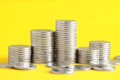 Photo of Salary concept. Stacked coins on yellow background