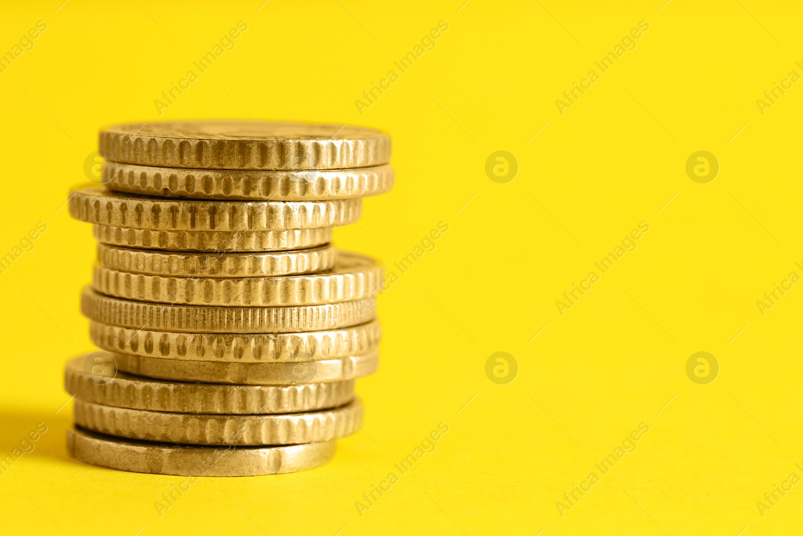 Photo of Salary concept. Stacked coins on yellow background, closeup. Space for text