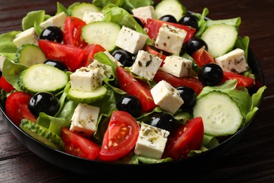 Photo of Delicious salad with feta cheese on wooden table, closeup