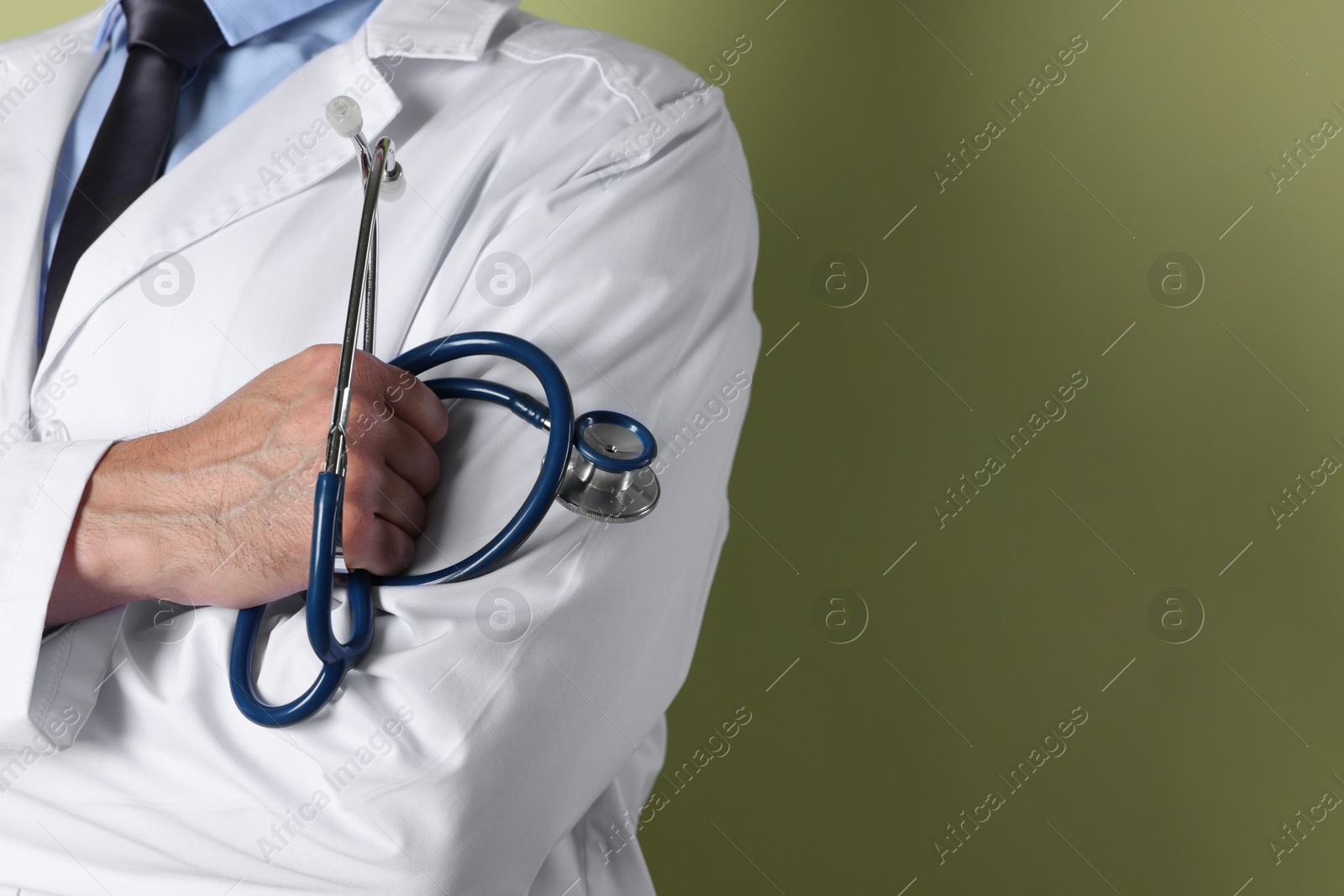 Photo of Doctor with stethoscope on olive background, closeup. Space for text