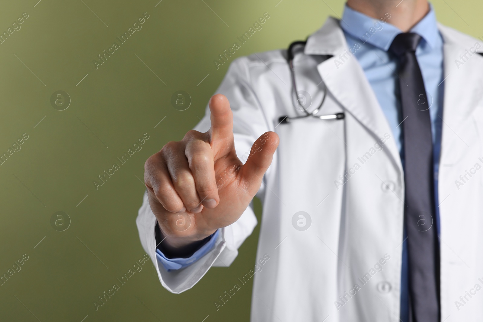 Photo of Doctor pointing at something on olive background, closeup