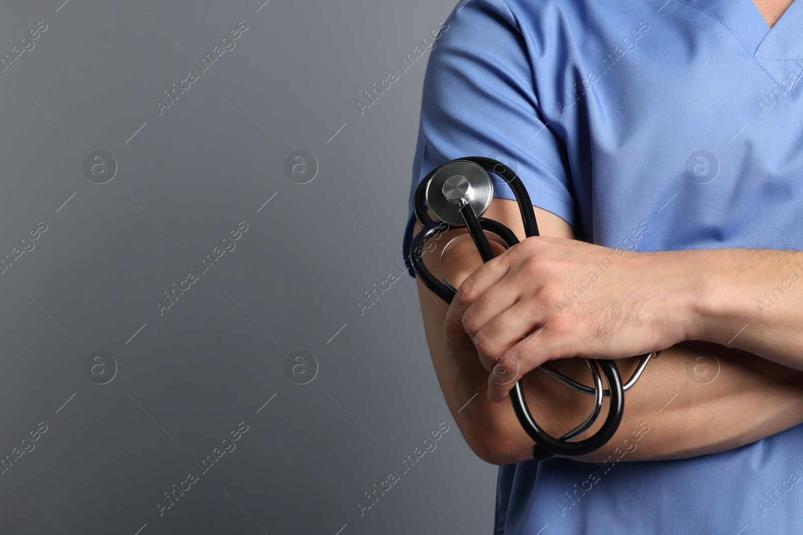 Photo of Nurse with stethoscope on grey background, closeup. Space for text