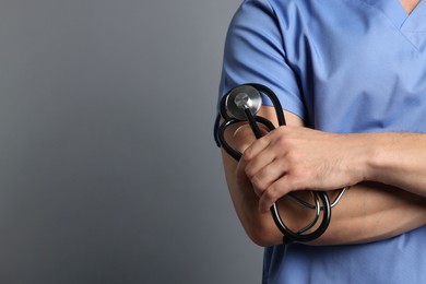 Photo of Nurse with stethoscope on grey background, closeup. Space for text