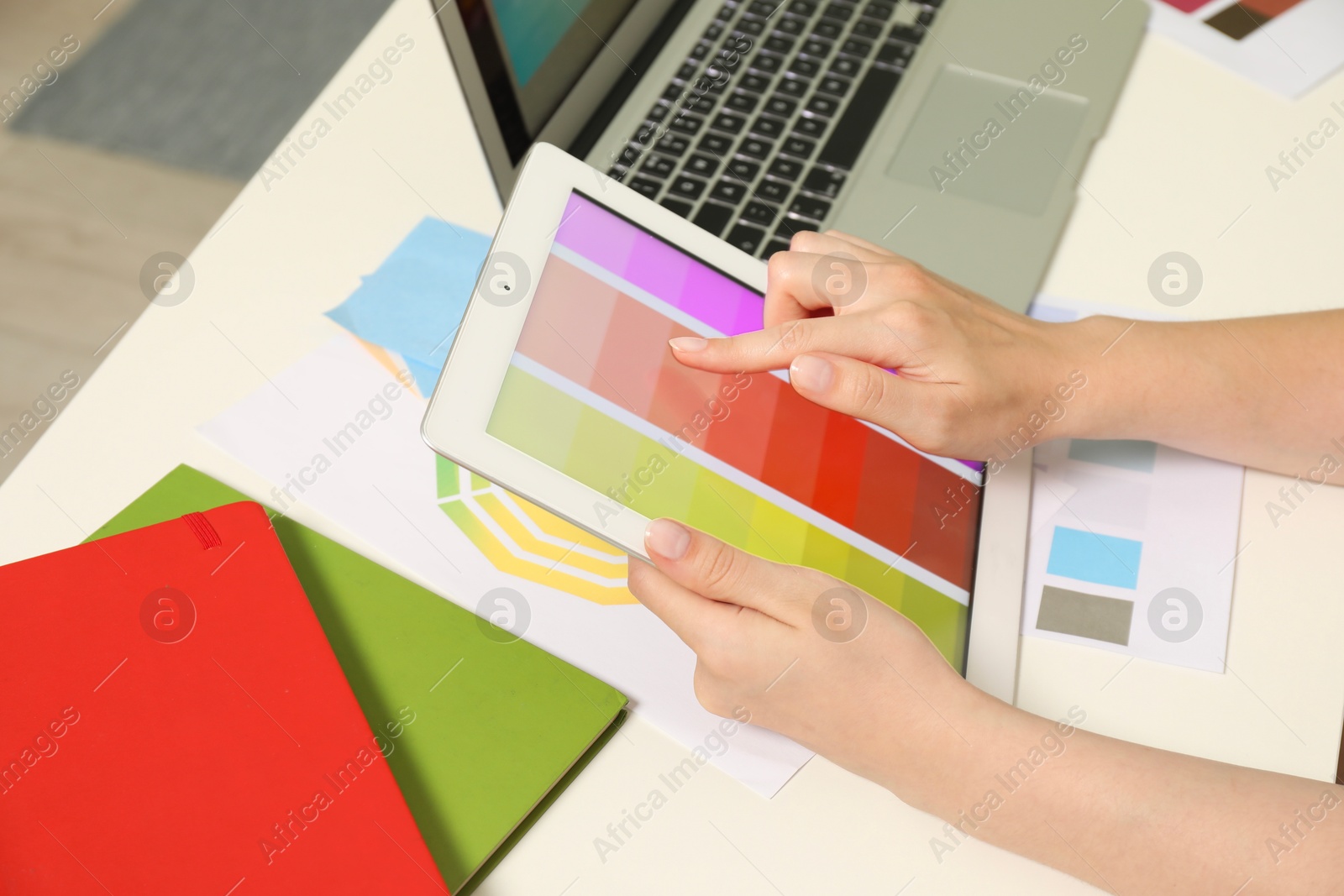 Photo of Website designer working with color palette on tablet at table, closeup