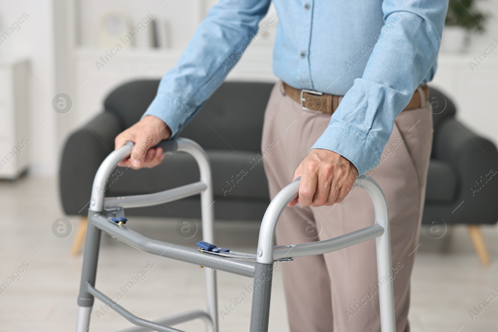 Photo of Senior man using walking frame at home, closeup