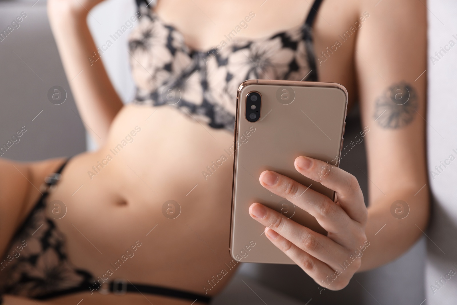 Photo of Prostitution. Webcam model in underwear working with smartphone, selective focus