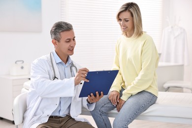 Photo of Healthcare worker with clipboard and patient in hospital