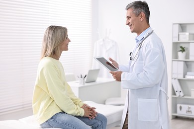 Healthcare worker with tablet and patient in hospital