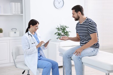 Photo of Healthcare worker with tablet and patient in hospital