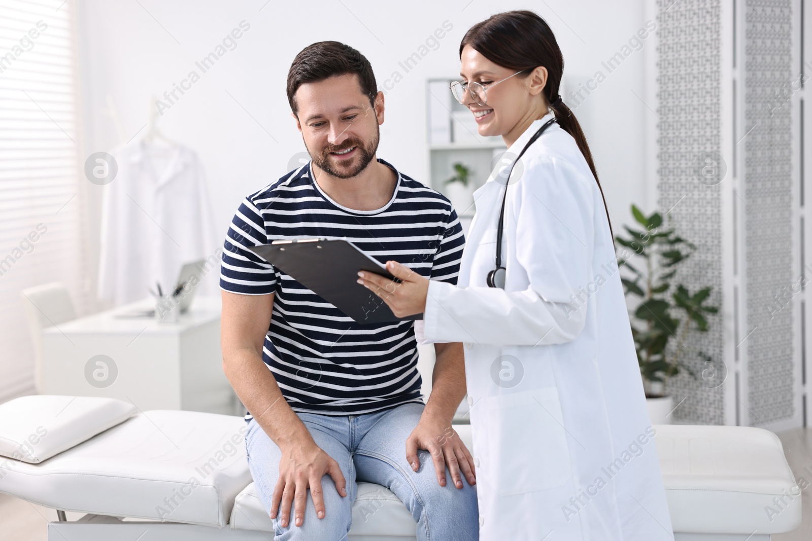 Photo of Healthcare worker with clipboard and patient in hospital