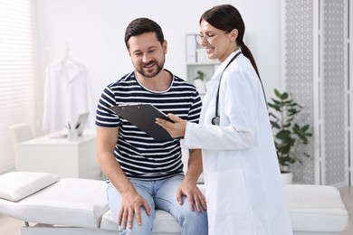 Healthcare worker with clipboard and patient in hospital