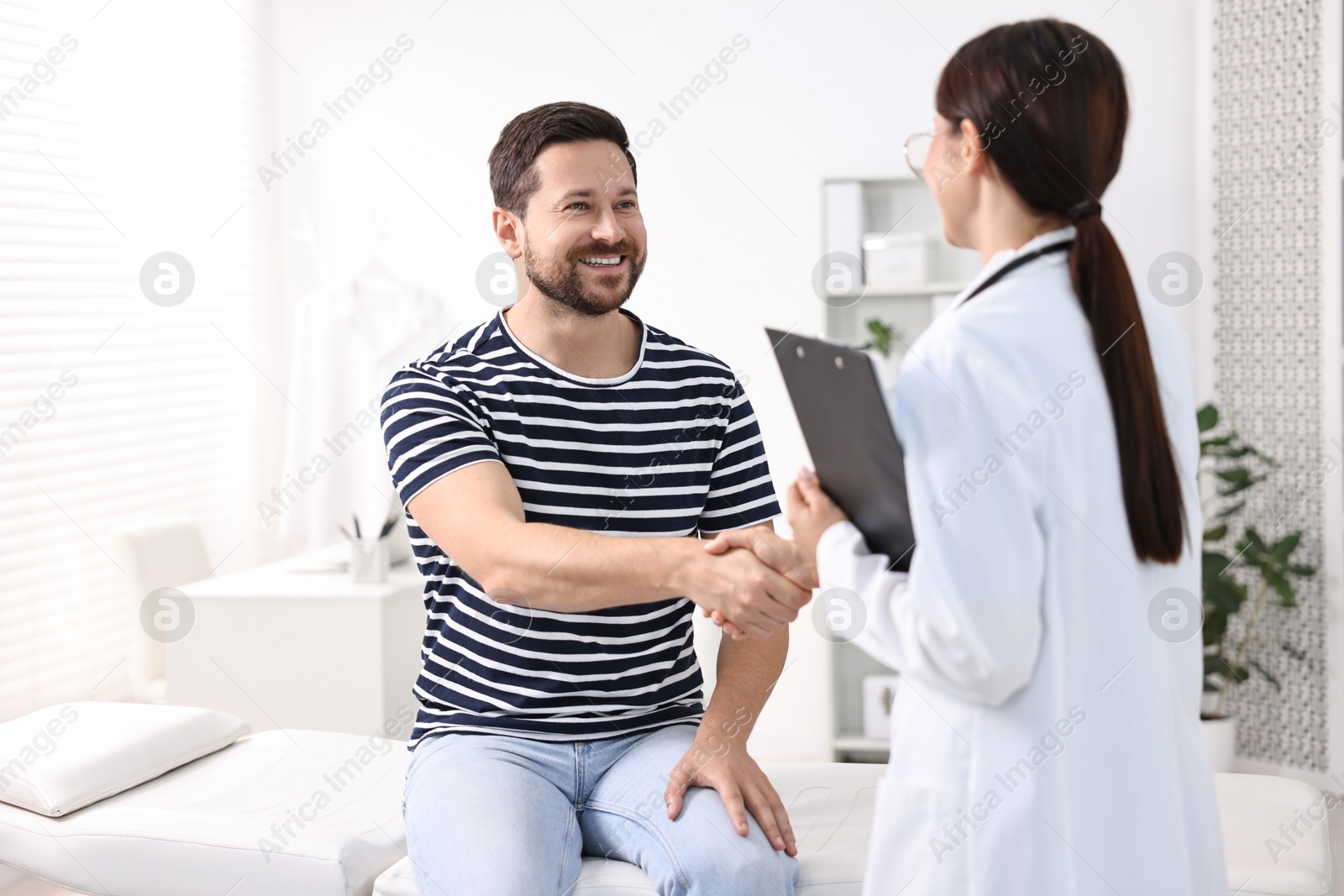 Photo of Healthcare worker shaking hands with patient in hospital