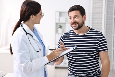 Healthcare worker with clipboard and patient in hospital