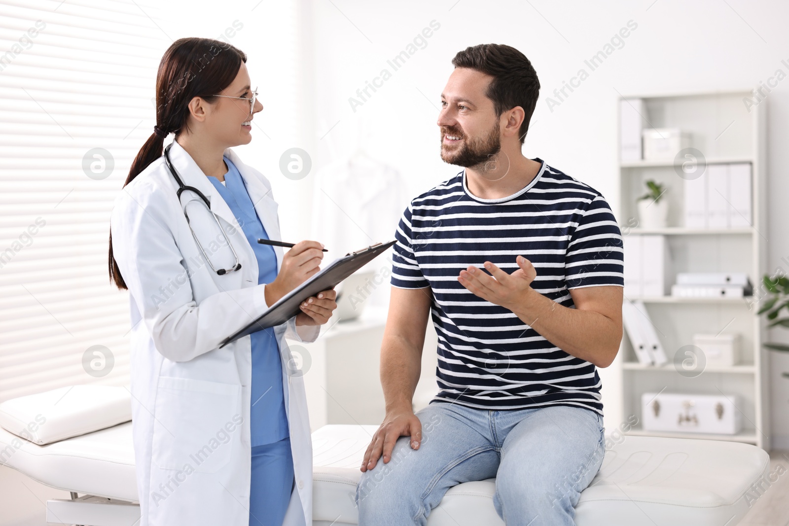 Photo of Healthcare worker with clipboard and patient in hospital