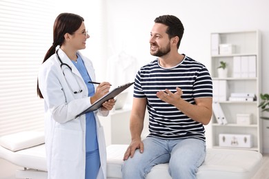 Healthcare worker with clipboard and patient in hospital