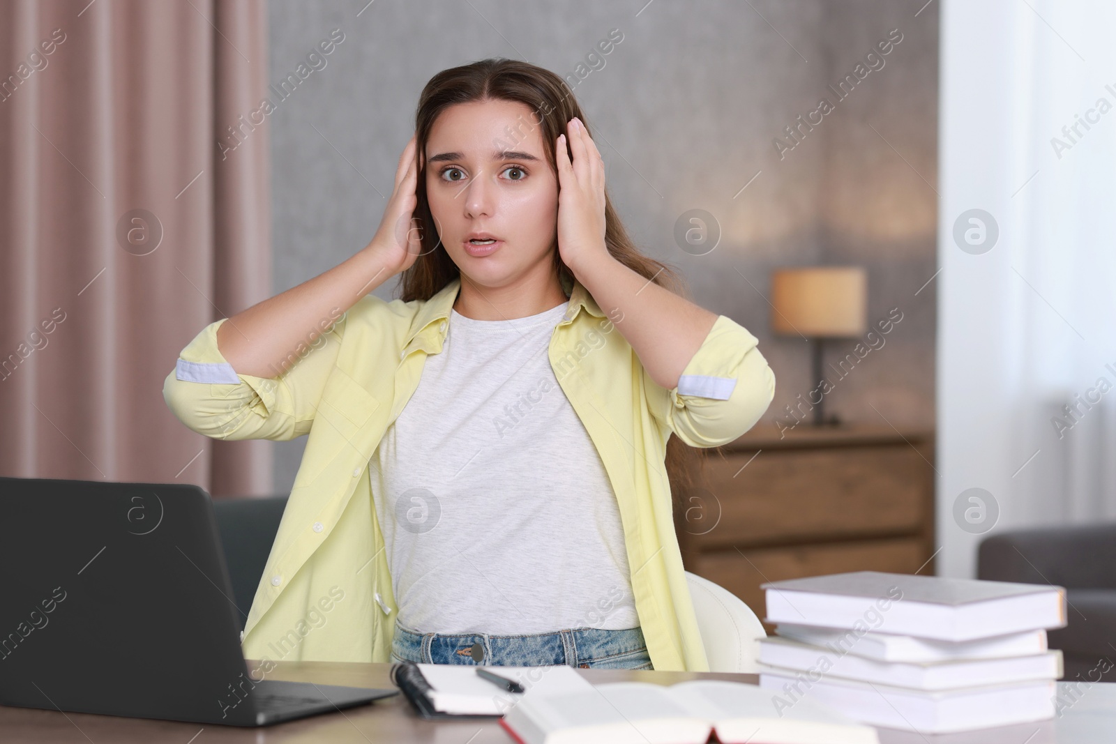 Photo of Young student having stress before exam at desk