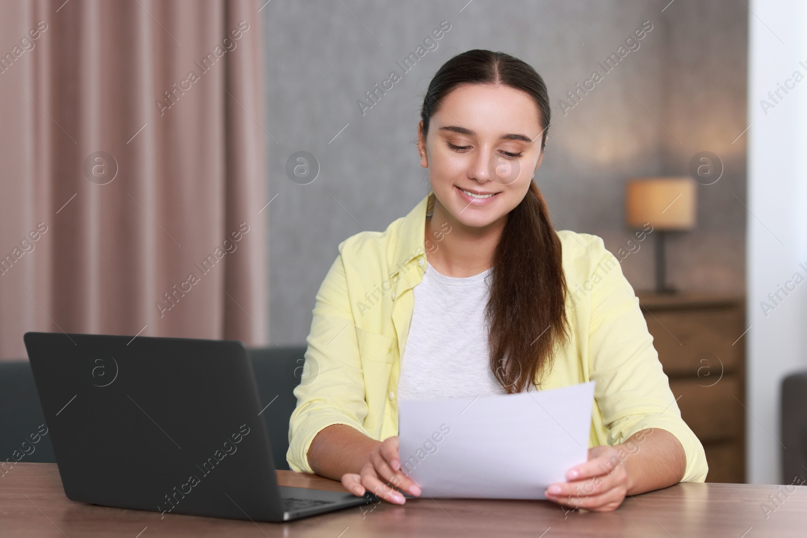 Photo of Young student with sheet happy about her good exam result at workplace