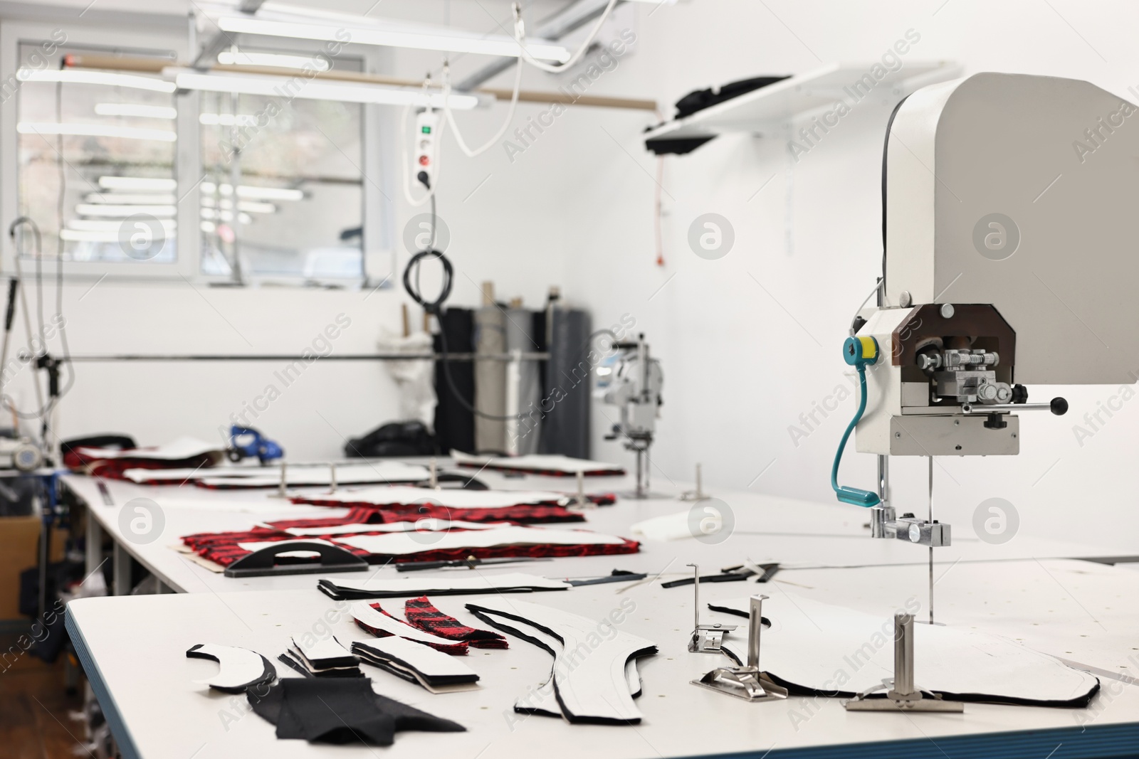 Photo of Professional workshop with different fabrics, white table and tools