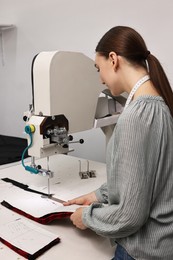 Young woman working at white table in professional workshop